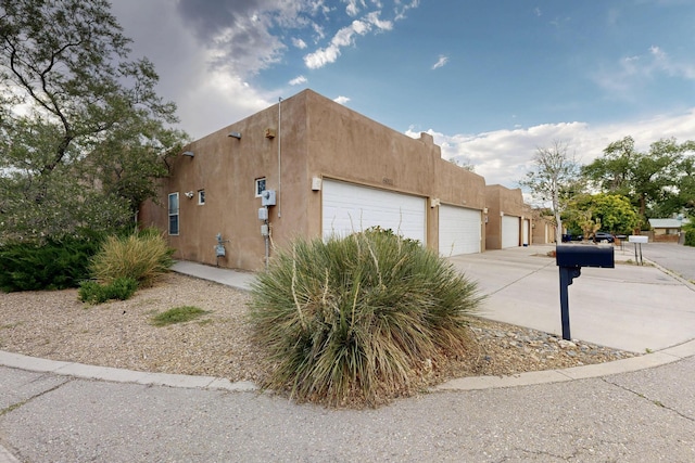 6021 Alamosa Way NW, Albuquerque, NM 87107 - view of home's exterior featuring stucco siding, concrete driveway, and an attached garage