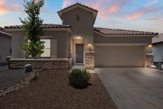 6873 Cleary Loop NE, Rio Rancho, NM 87144 - mediterranean / spanish home with a tile roof, concrete driveway, stone siding, and a garage