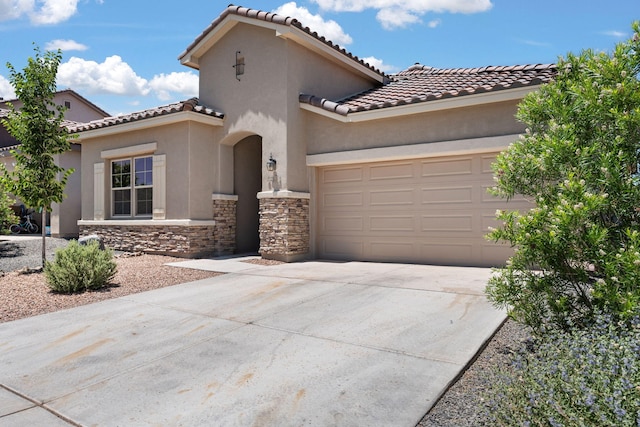 6873 Cleary Loop NE, Rio Rancho, NM 87144 - mediterranean / spanish-style house with concrete driveway, a garage, a tiled roof, and stone siding