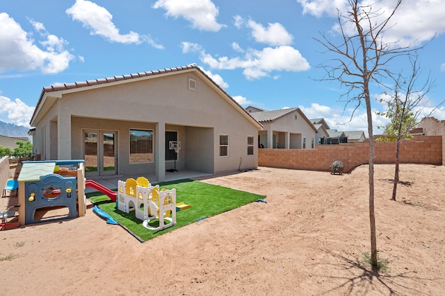 6873 Cleary Loop NE, Rio Rancho, NM 87144 - back of property with a fenced backyard, stucco siding, a tiled roof, and a patio