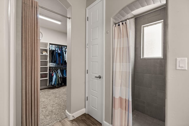 6873 Cleary Loop NE, Rio Rancho, NM 87144 - full bathroom with a tile shower, wood finished floors, and a spacious closet