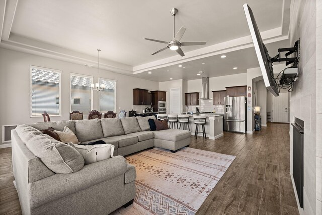6873 Cleary Loop NE, Rio Rancho, NM 87144 - living room with a chandelier, ceiling fan, a raised ceiling, recessed lighting, and dark wood-style flooring