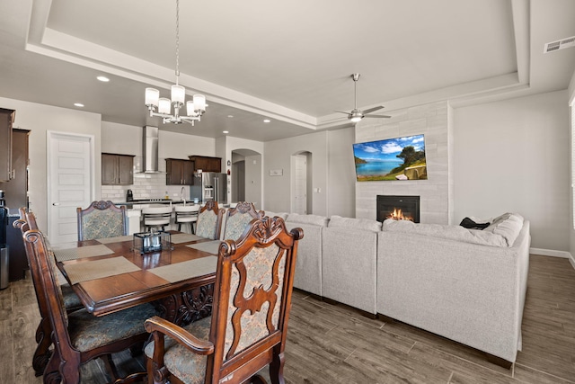 6873 Cleary Loop NE, Rio Rancho, NM 87144 - dining area featuring a tray ceiling, arched walkways, ceiling fan, wood finished floors, and recessed lighting