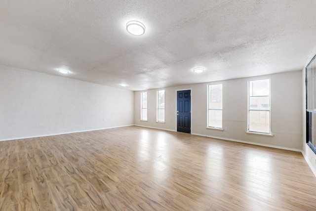 4807 Parsifal St NE, Albuquerque, NM 87111 - unfurnished living room featuring light wood finished floors and a textured ceiling