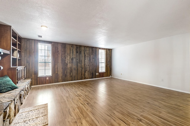 4807 Parsifal St NE, Albuquerque, NM 87111 - unfurnished living room with wood finished floors, wood walls, and a textured ceiling