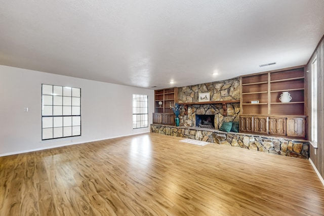 4807 Parsifal St NE, Albuquerque, NM 87111 - unfurnished living room with wood finished floors, built in shelves, and a fireplace