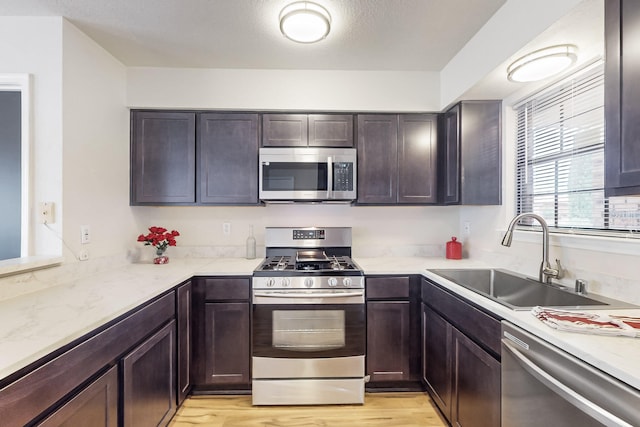 4807 Parsifal St NE, Albuquerque, NM 87111 - kitchen with stainless steel appliances, dark brown cabinets, and light wood-style floors