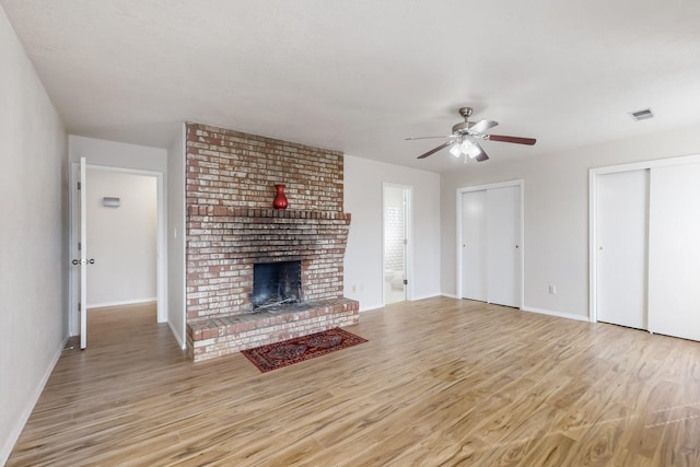 4807 Parsifal St NE, Albuquerque, NM 87111 - unfurnished living room featuring light wood-style floors, ceiling fan, and a brick fireplace