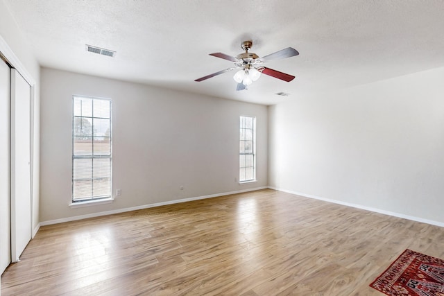 4807 Parsifal St NE, Albuquerque, NM 87111 - empty room featuring plenty of natural light, light wood-style floors, a ceiling fan, and a textured ceiling