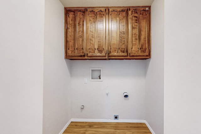 4807 Parsifal St NE, Albuquerque, NM 87111 - laundry area with gas dryer hookup, cabinet space, electric dryer hookup, light wood-style flooring, and hookup for a washing machine