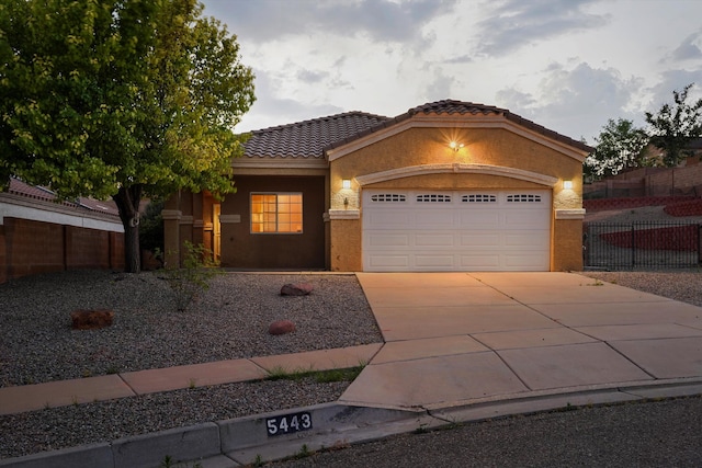 5443 Reserve Ct NE, Rio Rancho, NM 87144 - view of front facade featuring an attached garage, concrete driveway, stucco siding, and a tiled roof