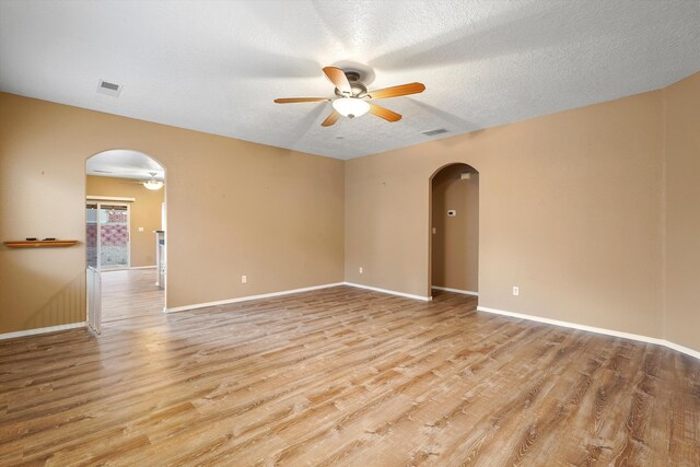 5443 Reserve Ct NE, Rio Rancho, NM 87144 - spare room with arched walkways, ceiling fan, light wood-style floors, and a textured ceiling