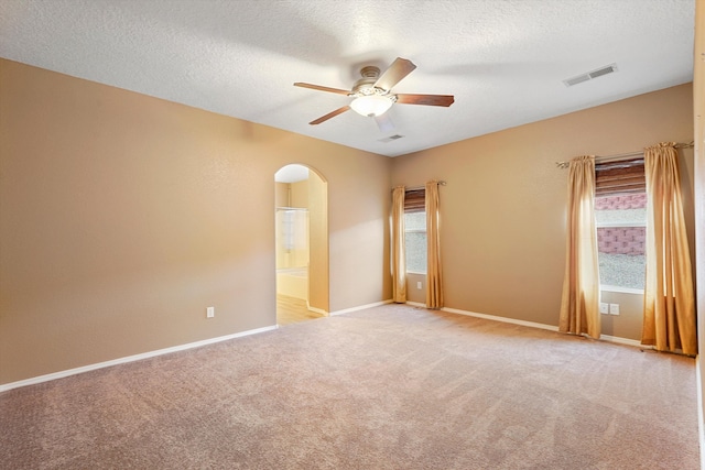 5443 Reserve Ct NE, Rio Rancho, NM 87144 - empty room with a ceiling fan, arched walkways, light colored carpet, and a textured ceiling