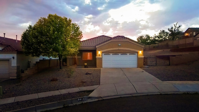 5443 Reserve Ct NE, Rio Rancho, NM 87144 - mediterranean / spanish-style house with a garage, driveway, stucco siding, and a tiled roof