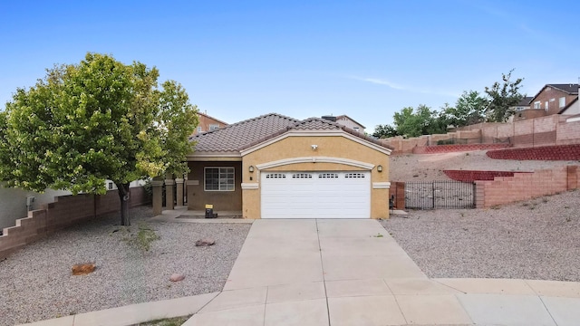 5443 Reserve Ct NE, Rio Rancho, NM 87144 - view of front facade with an attached garage, concrete driveway, stucco siding, a tile roof, and a gate