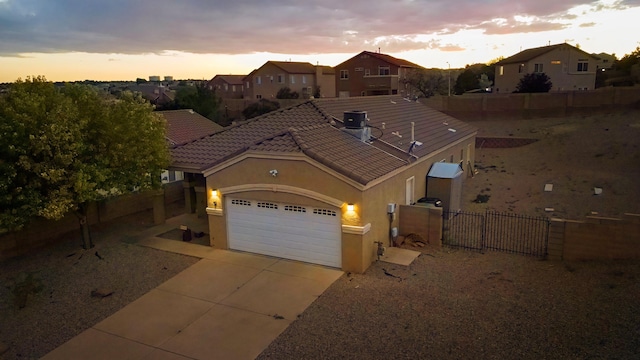 5443 Reserve Ct NE, Rio Rancho, NM 87144 - view of front of house with stucco siding, a garage, driveway, a fenced backyard, and a gate