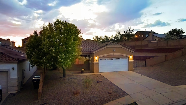 5443 Reserve Ct NE, Rio Rancho, NM 87144 - mediterranean / spanish house featuring a garage, stucco siding, concrete driveway, and a tiled roof
