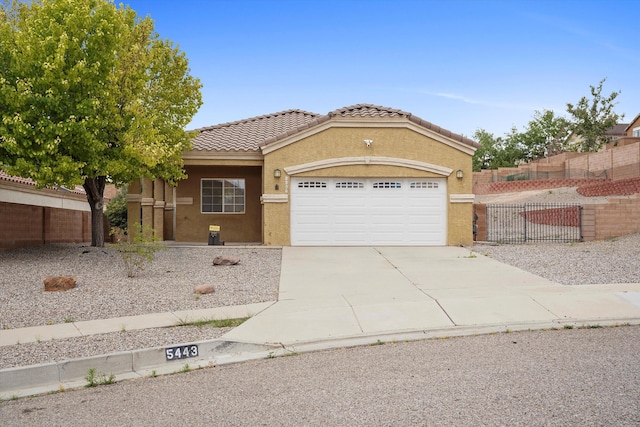 5443 Reserve Ct NE, Rio Rancho, NM 87144 - view of front of home featuring stucco siding, a garage, concrete driveway, and a tiled roof