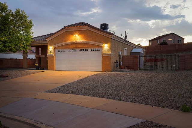 5443 Reserve Ct NE, Rio Rancho, NM 87144 - view of front of home featuring concrete driveway, a tiled roof, an attached garage, stucco siding, and a gate