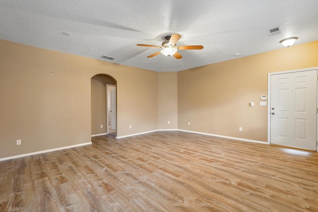 5443 Reserve Ct NE, Rio Rancho, NM 87144 - unfurnished room featuring arched walkways, a ceiling fan, light wood-style floors, and a textured ceiling