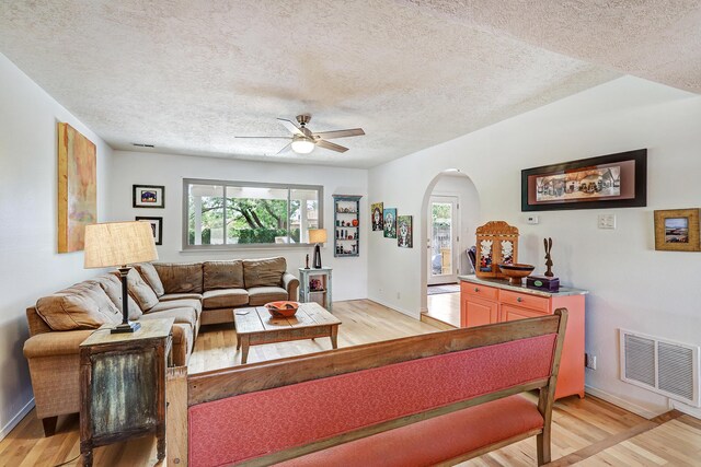7209 Yorktown Ave NE, Albuquerque, NM 87109 - living room with a textured ceiling, light wood-style floors, arched walkways, healthy amount of natural light, and a ceiling fan
