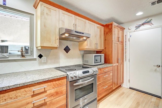 7209 Yorktown Ave NE, Albuquerque, NM 87109 - kitchen featuring stainless steel electric range oven, under cabinet range hood, light wood finished floors, tile counters, and tasteful backsplash
