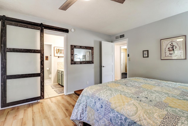 7209 Yorktown Ave NE, Albuquerque, NM 87109 - bedroom with a barn door, light wood finished floors, and ensuite bathroom