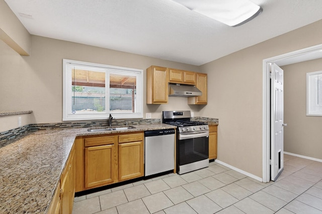 6312 Zimmerman Ave NE, Albuquerque, NM 87110 - kitchen with appliances with stainless steel finishes, under cabinet range hood, light stone countertops, and light tile patterned flooring