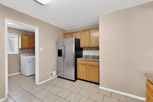 6312 Zimmerman Ave NE, Albuquerque, NM 87110 - kitchen with stainless steel fridge, washer / clothes dryer, light tile patterned floors, light stone countertops, and a textured ceiling