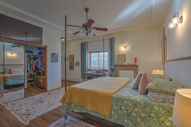 400 Paseo Del Bosque NW, Albuquerque, NM 87114 - bedroom featuring wood finished floors, a baseboard heating unit, a closet, and ceiling fan