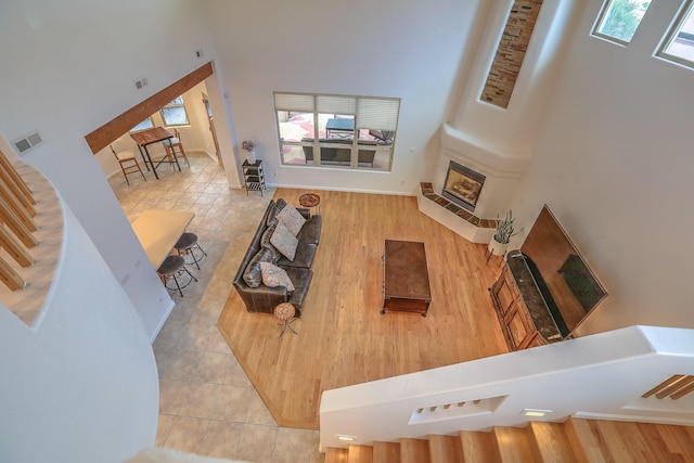9404 Bear Mountain Trl NE, Albuquerque, NM 87113 - tiled living area featuring plenty of natural light, a high ceiling, stairway, and a fireplace