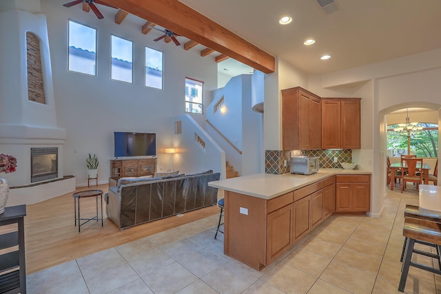 9404 Bear Mountain Trl NE, Albuquerque, NM 87113 - kitchen with ceiling fan, open floor plan, decorative backsplash, arched walkways, and a kitchen bar