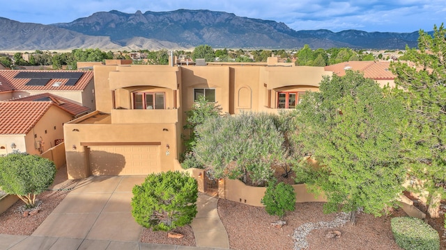9404 Bear Mountain Trl NE, Albuquerque, NM 87113 - southwest-style home with stucco siding, driveway, a mountain view, and a garage