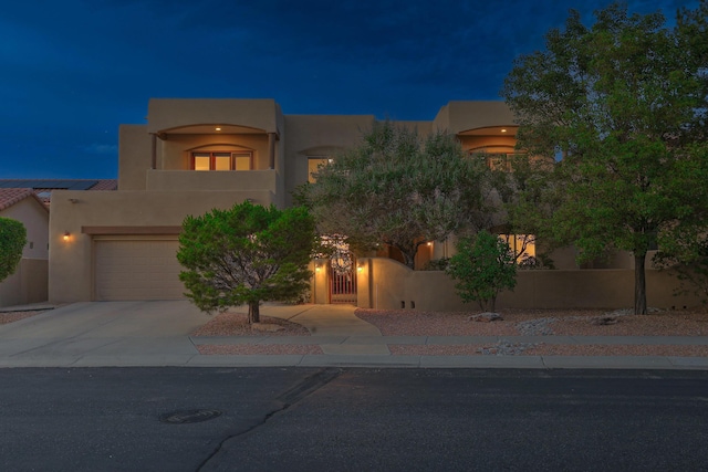 9404 Bear Mountain Trl NE, Albuquerque, NM 87113 - southwest-style home featuring stucco siding, a fenced front yard, driveway, and an attached garage