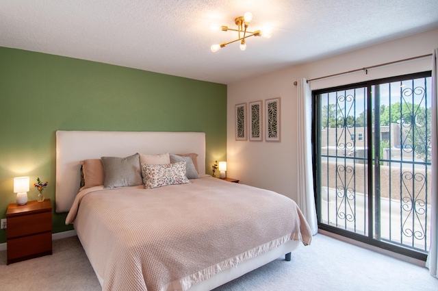 6820 Los Trechos Ct NE, Albuquerque, NM 87109 - carpeted bedroom with access to exterior, a chandelier, and a textured ceiling