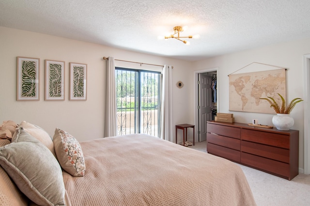 6820 Los Trechos Ct NE, Albuquerque, NM 87109 - bedroom featuring light colored carpet, a chandelier, a textured ceiling, a spacious closet, and access to outside