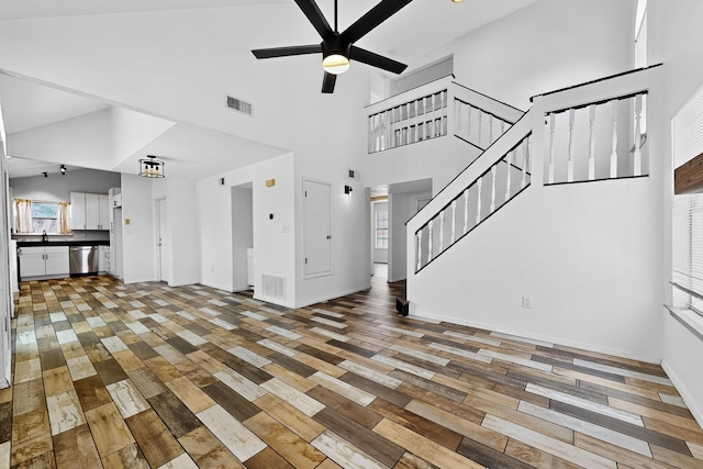 4429 Cattleya Rd NW, Albuquerque, NM 87120 - unfurnished living room with light wood-style flooring, a ceiling fan, stairway, and a towering ceiling