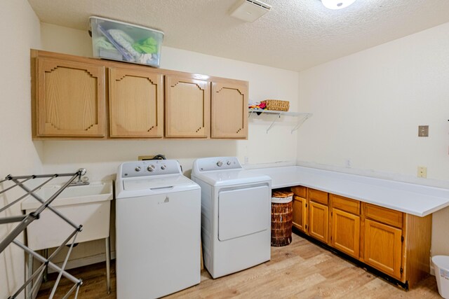 3700 Alamogordo Dr NW, Albuquerque, NM 87120 - laundry area with cabinet space, light wood finished floors, washer and clothes dryer, and a textured ceiling