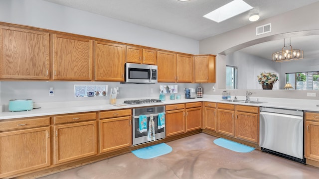 3915 Tundra Swan Ct NW, Albuquerque, NM 87120 - kitchen with stainless steel appliances, concrete flooring, light countertops, arched walkways, and a skylight