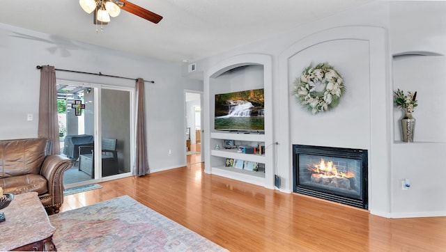 3915 Tundra Swan Ct NW, Albuquerque, NM 87120 - living area with wood finished floors, a glass covered fireplace, and ceiling fan