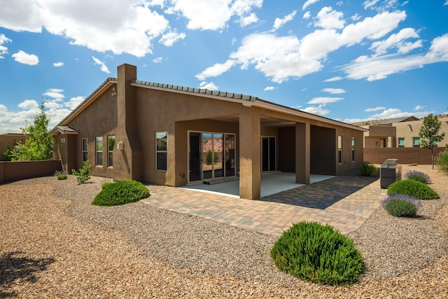 5402 Grays Peak Trl NE, Rio Rancho, NM 87144 - back of house with stucco siding, a patio area, and a chimney