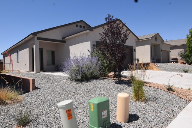 10812 Caresso SW, Albuquerque, NM 87121 - view of front facade with a garage, stucco siding, and concrete driveway