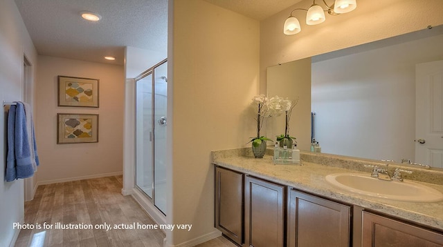 1652 Maggie Ct NE, Rio Rancho, NM 87144 - full bath featuring vanity, a shower stall, wood finished floors, recessed lighting, and a textured ceiling