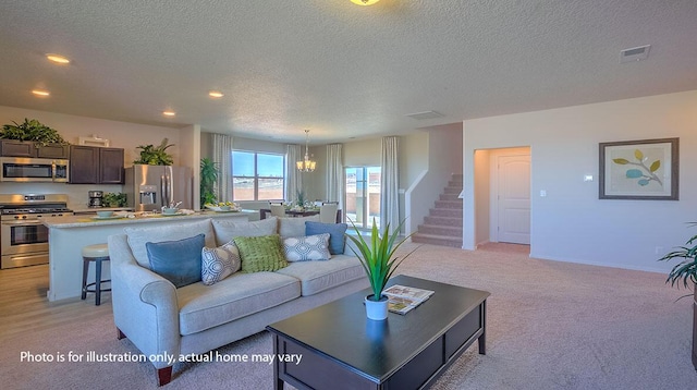 1652 Maggie Ct NE, Rio Rancho, NM 87144 - living area featuring light colored carpet, a textured ceiling, stairs, a chandelier, and recessed lighting