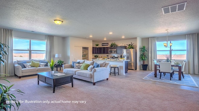 1652 Maggie Ct NE, Rio Rancho, NM 87144 - living area with a textured ceiling, a chandelier, recessed lighting, and light carpet