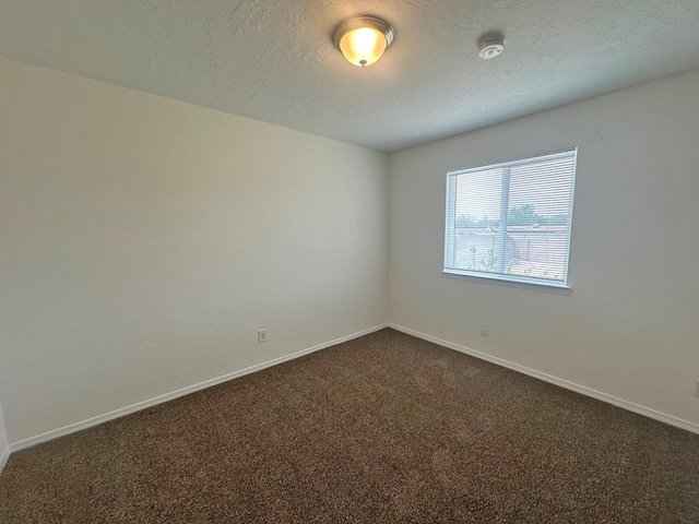 5612 Territorial Rd NW, Albuquerque, NM 87120 - spare room featuring a smoke detector, dark colored carpet, and a textured ceiling