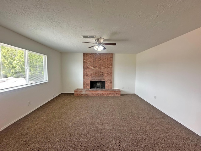 5612 Territorial Rd NW, Albuquerque, NM 87120 - unfurnished living room featuring a ceiling fan, a brick fireplace, dark carpet, and a textured ceiling
