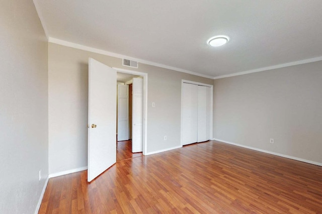 9815 Osuna Rd NE, Albuquerque, NM 87111 - unfurnished bedroom featuring wood finished floors, crown molding, and a closet