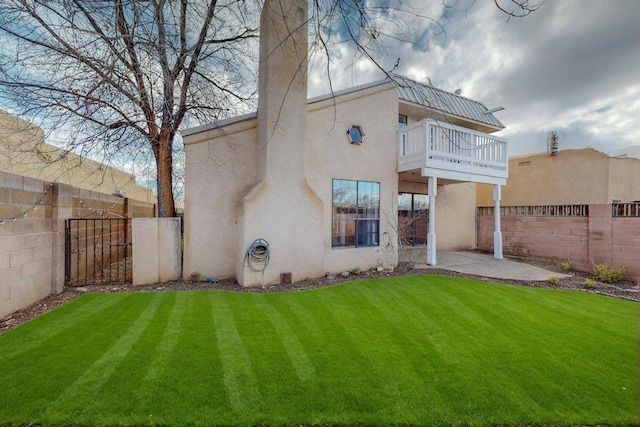 9815 Osuna Rd NE, Albuquerque, NM 87111 - rear view of property featuring a balcony, stucco siding, a fenced backyard, a patio, and a gate