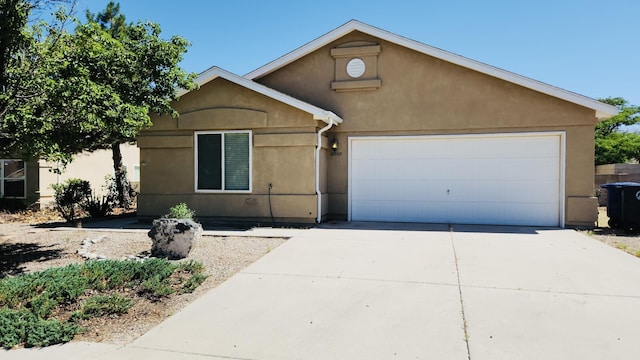 6008 Burgos Ave NW, Albuquerque, NM 87114 - view of front of house with driveway, a garage, and stucco siding